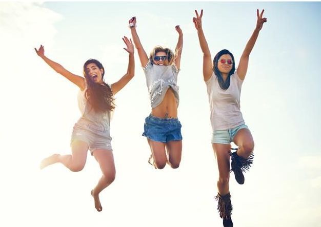 Three women are jumping in the air with their arms in the air.