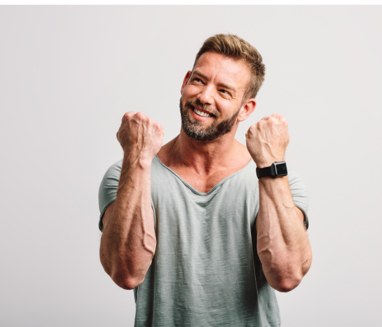 A man with a beard is raising his fists in the air.