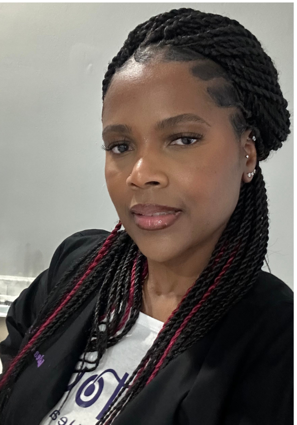 A woman with braids is wearing a black jacket and a white shirt.