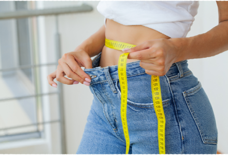A woman is measuring her waist with a tape measure.