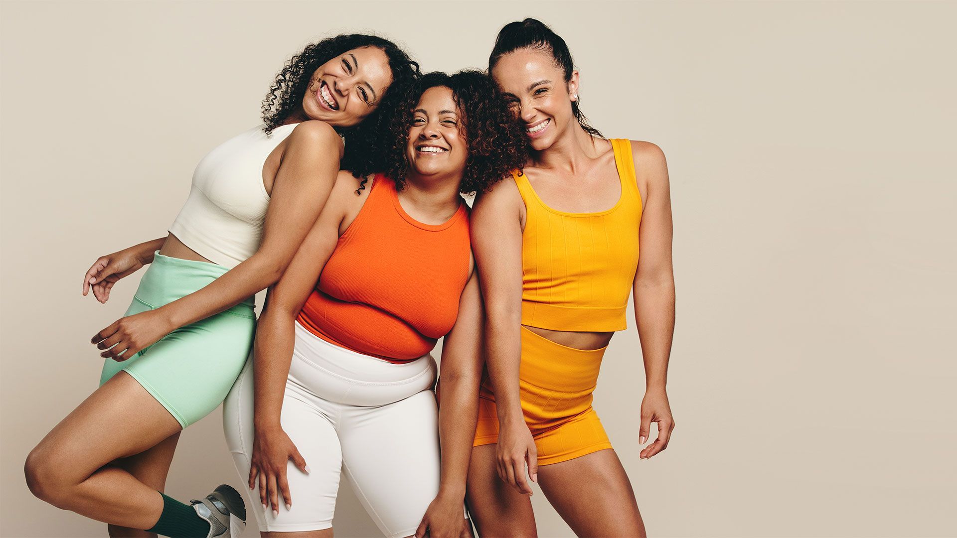 Three women are posing for a picture together and smiling.