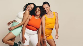 Three women are posing for a picture together and smiling.