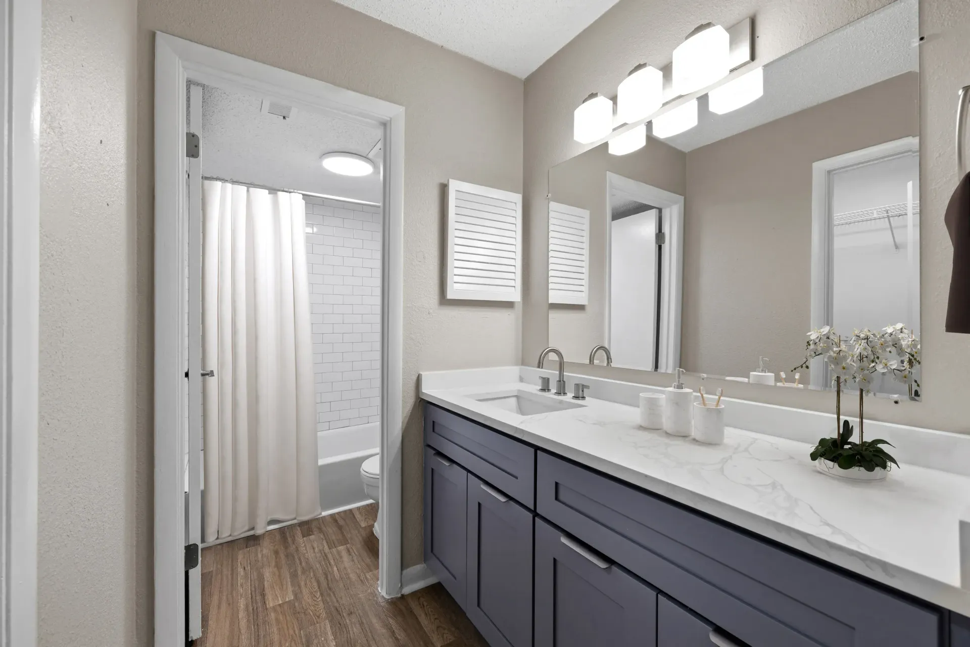 Bathroom with gray vanity, white countertop, and open doorway to shower at Mill House at East Cobb offers townhomes for rent in East Cobb, GA.