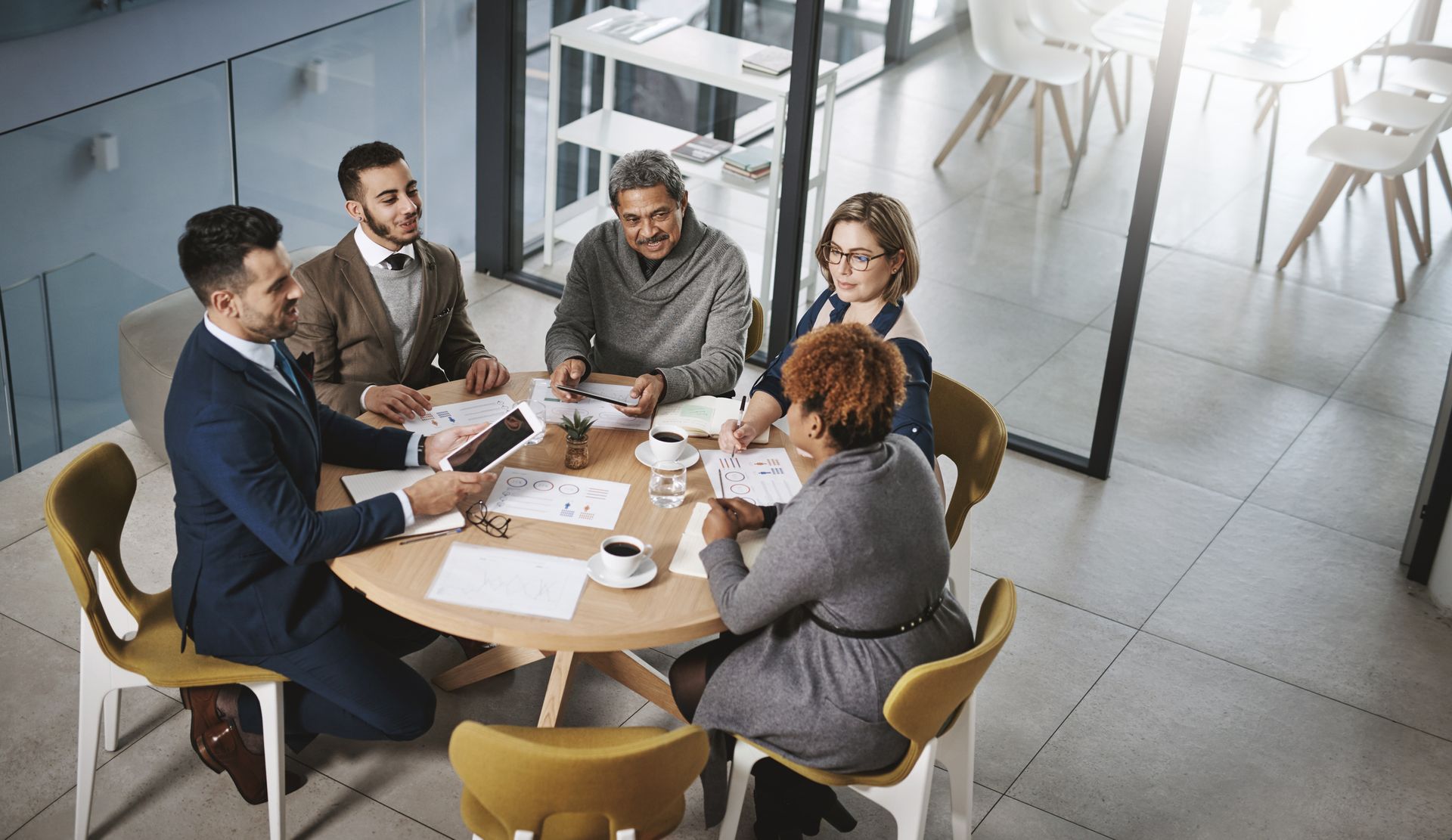 A group of people are sitting around a table having a meeting.