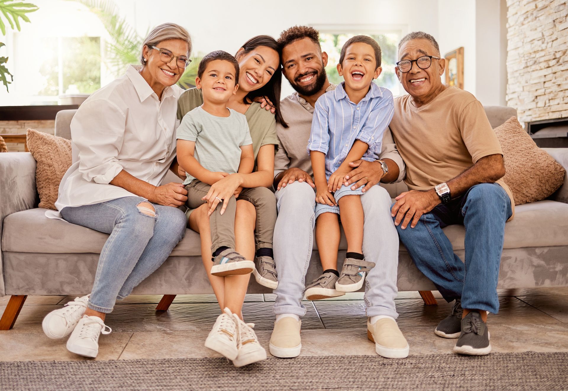 A family is sitting on a couch posing for a picture.