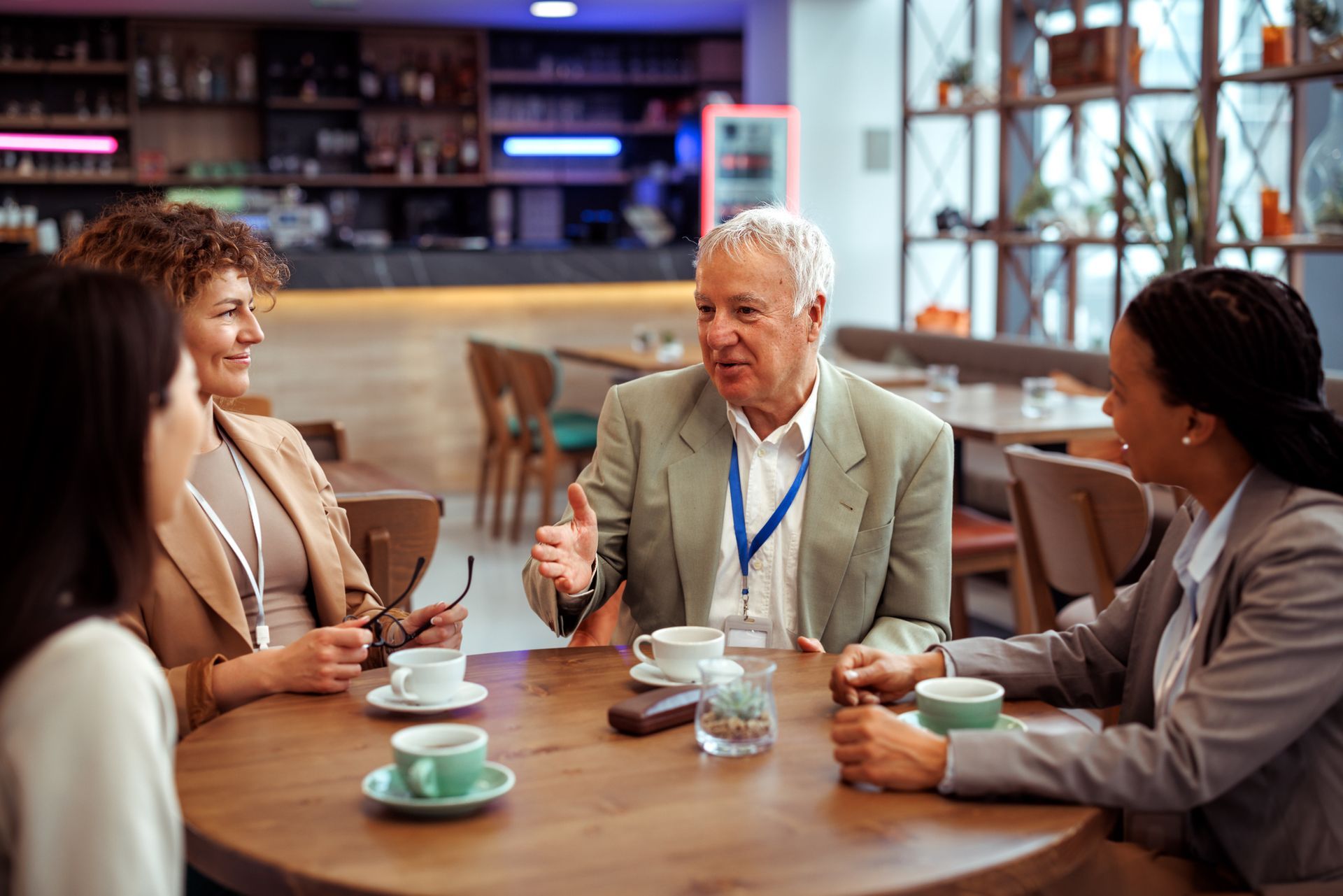 A group of people are sitting at a table in a restaurant having a conversation.