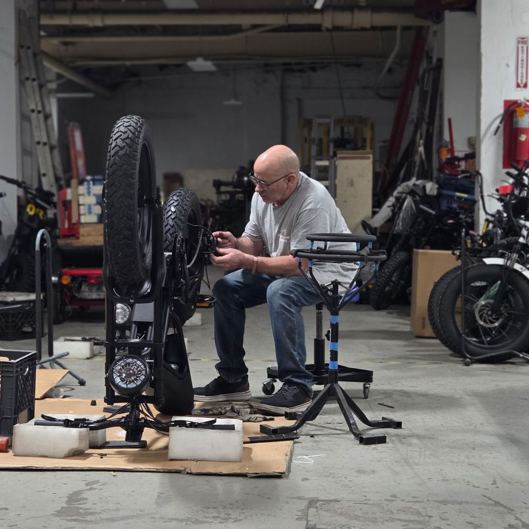A man is working on a bicycle in a garage