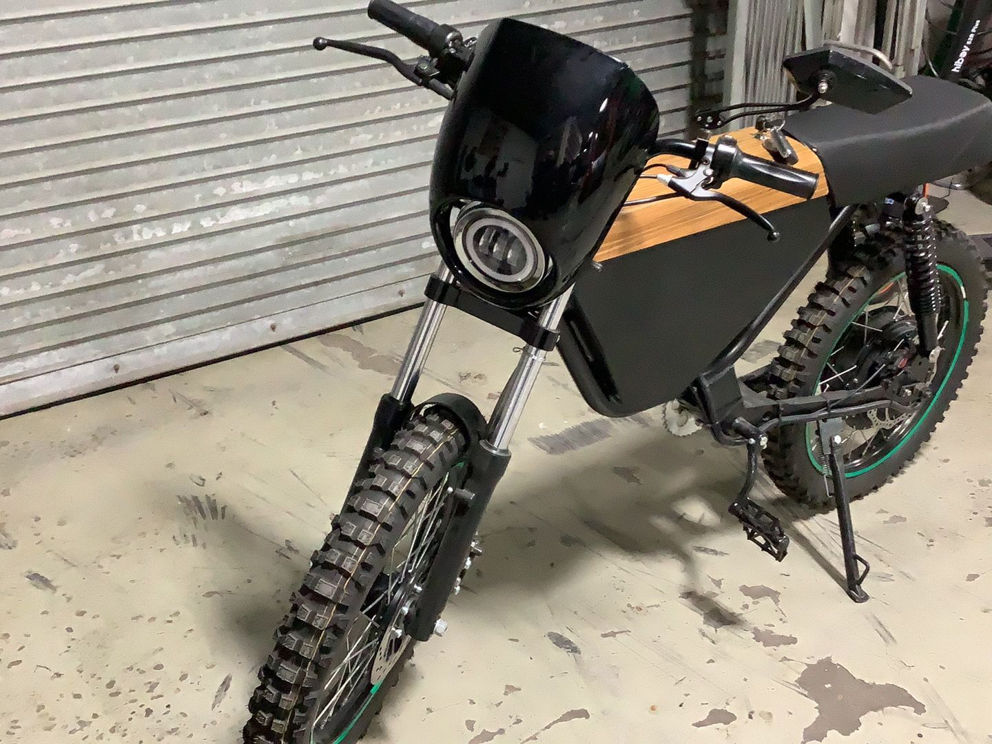 A black and orange dirt bike is parked in a garage.