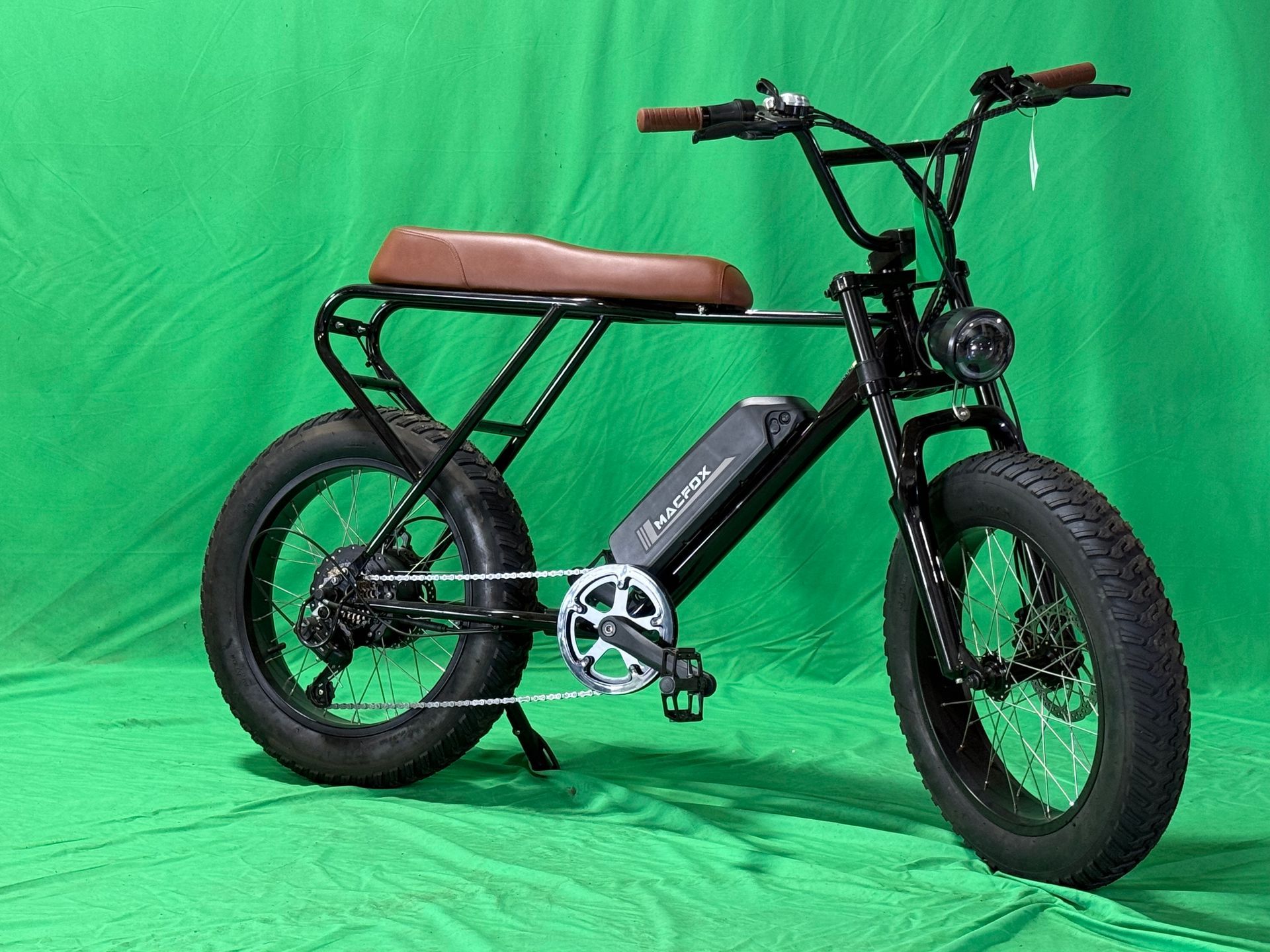 A black motorcycle is parked on a green background.