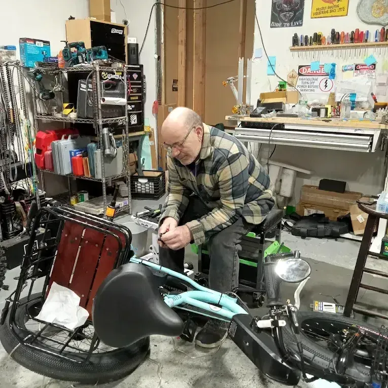 A man is working on a bicycle in a garage