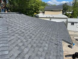 A man is working on the roof of a house.