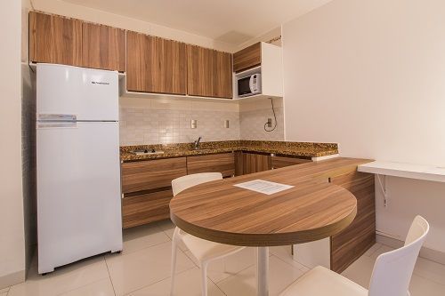 Una cocina con mesa y sillas y nevera.