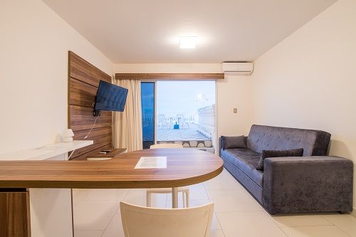 Un salón con sofá , mesa y televisión.