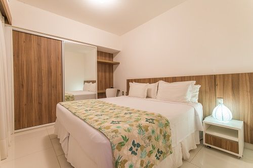 Un dormitorio con cama king size, mesa de noche y closet.