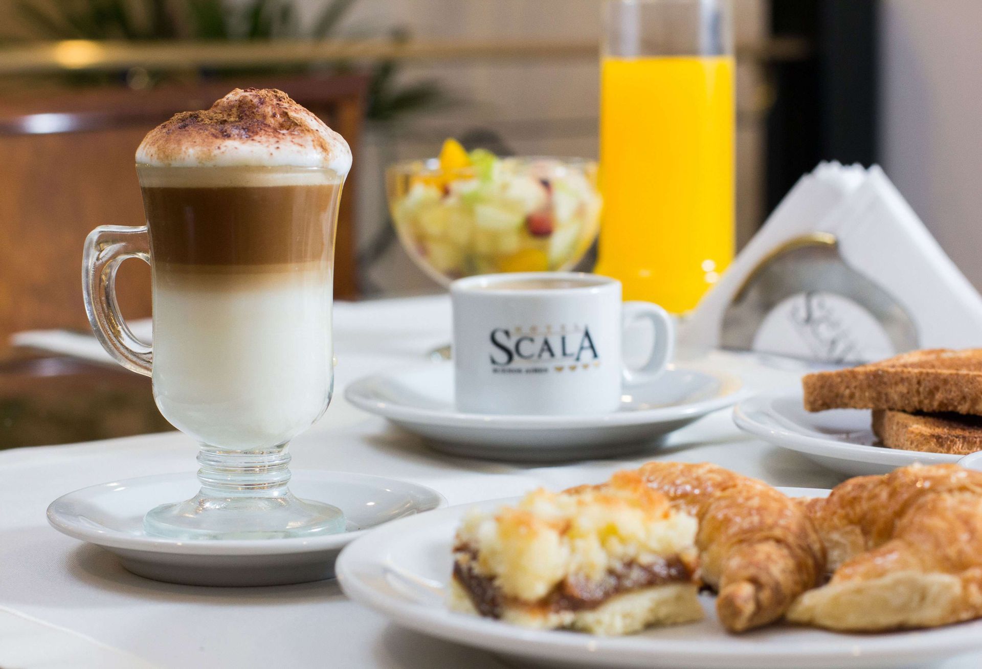 Una mesa cubierta con platos de comida y una taza de café scala