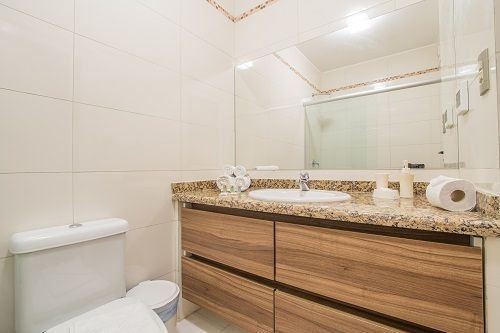 Un baño con inodoro, lavabo y espejo.