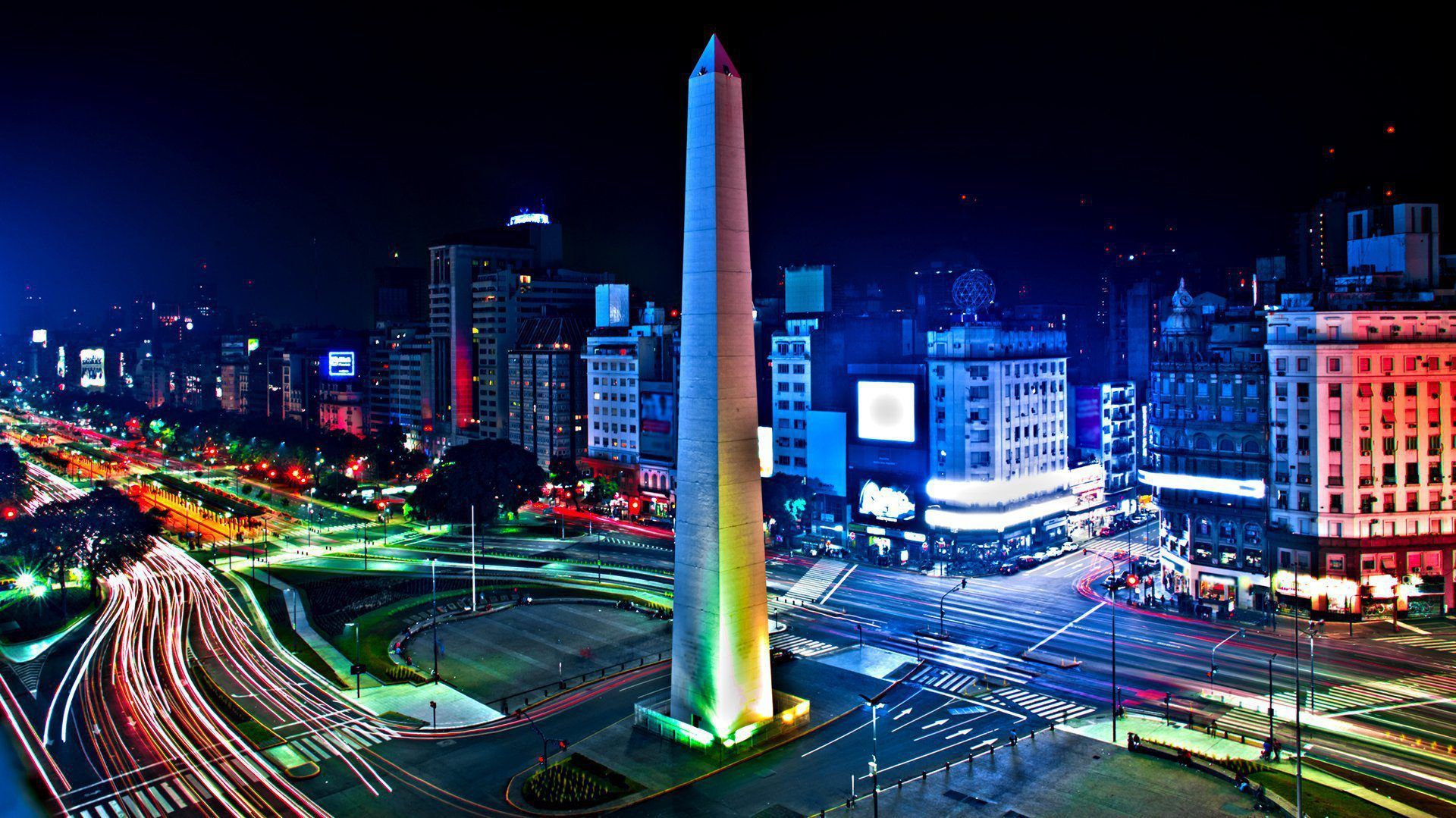 Un gran obelisco en medio de una ciudad por la noche