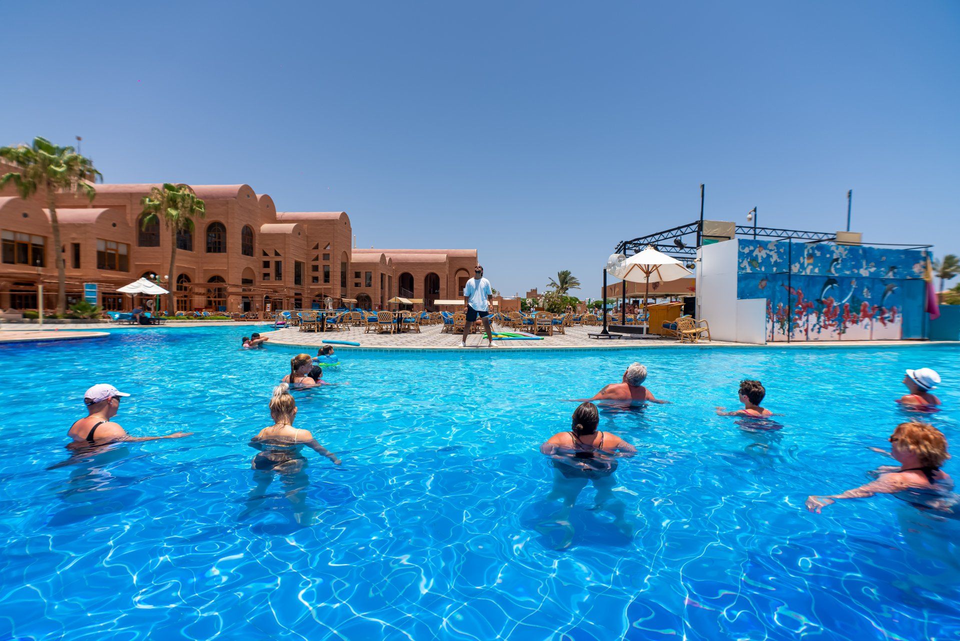 A group of people are swimming in a large swimming pool.