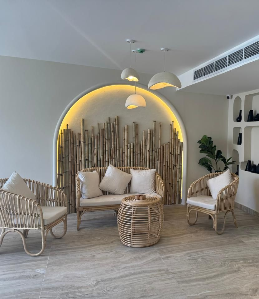 A patio with a table and chairs under a tent with pyramids in the background.