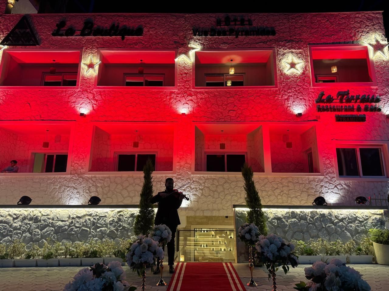 A large white building with red lights on it