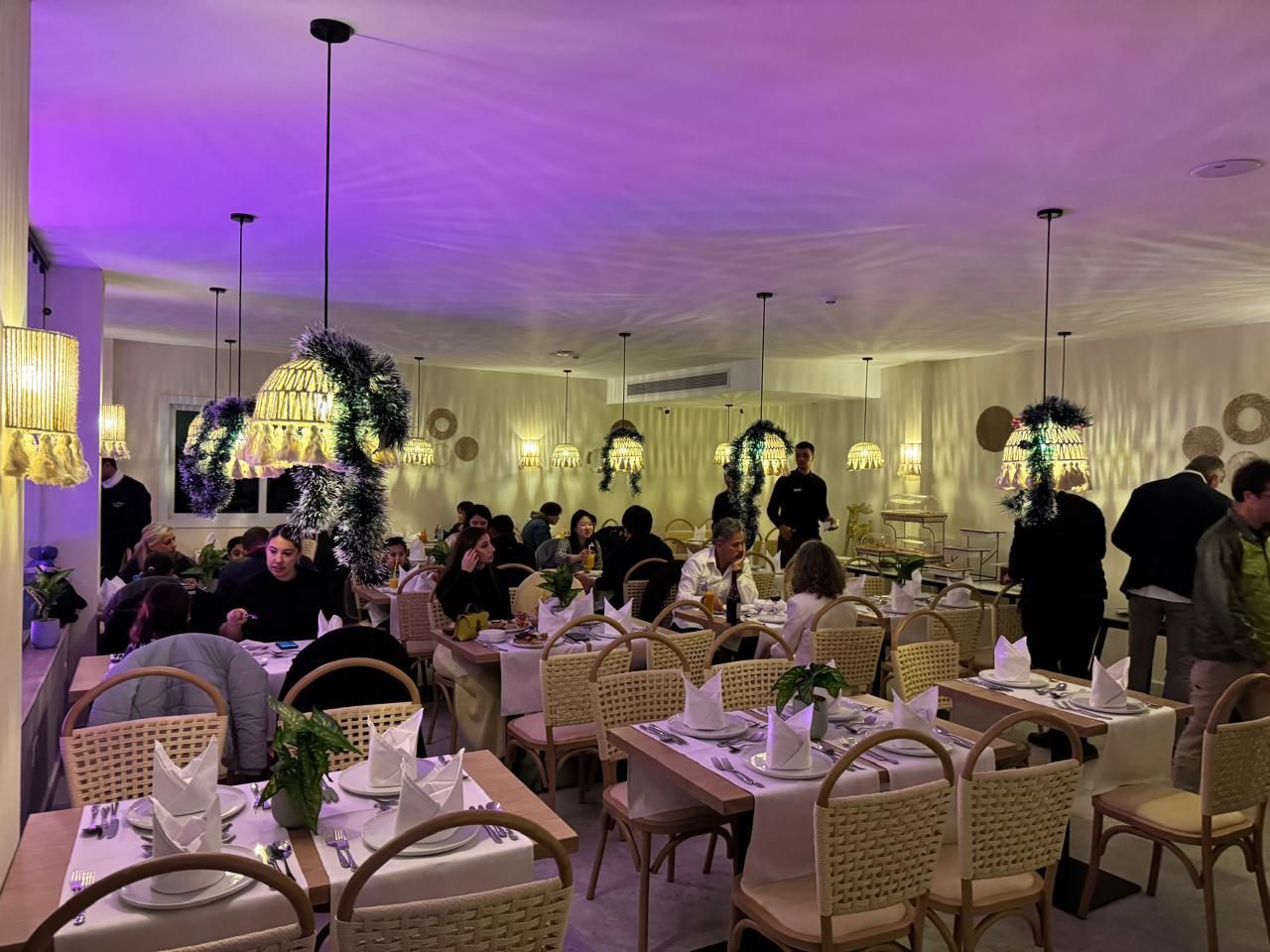 A group of people are sitting at tables in a restaurant.