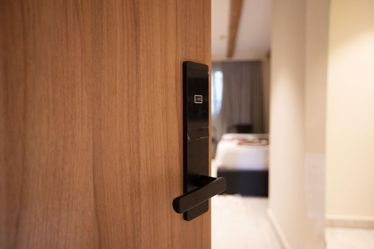 A hotel room with a wooden door and a black door handle.