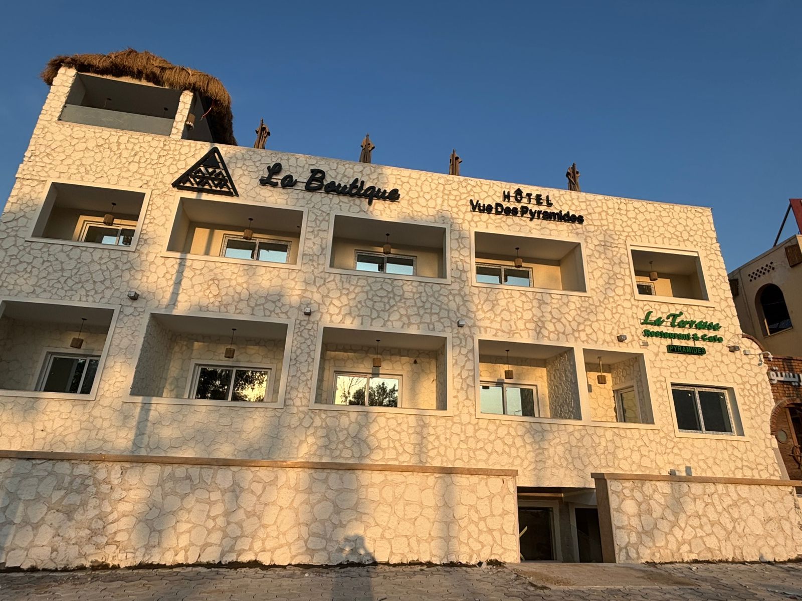 A large white building with a thatched roof is called la boutique