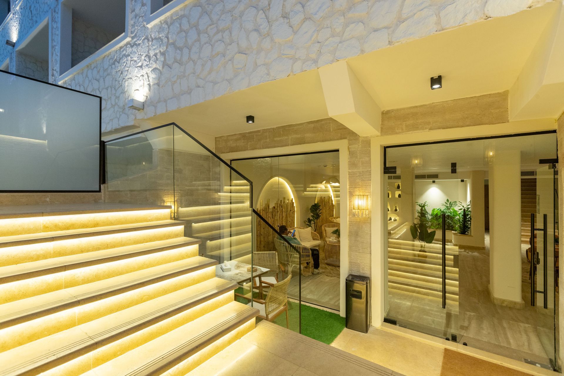 A reception area with a counter , chairs , lamps and a rug.