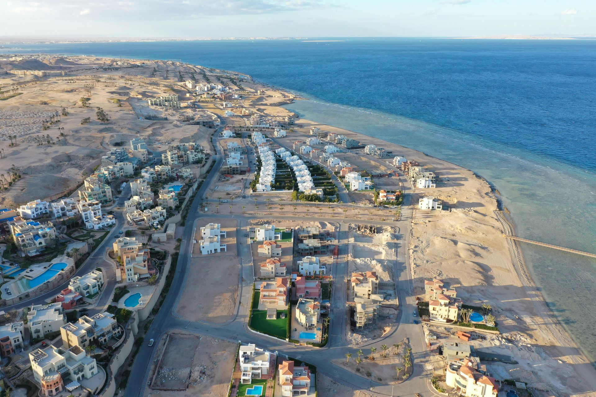 An aerial view of a residential area next to the ocean.