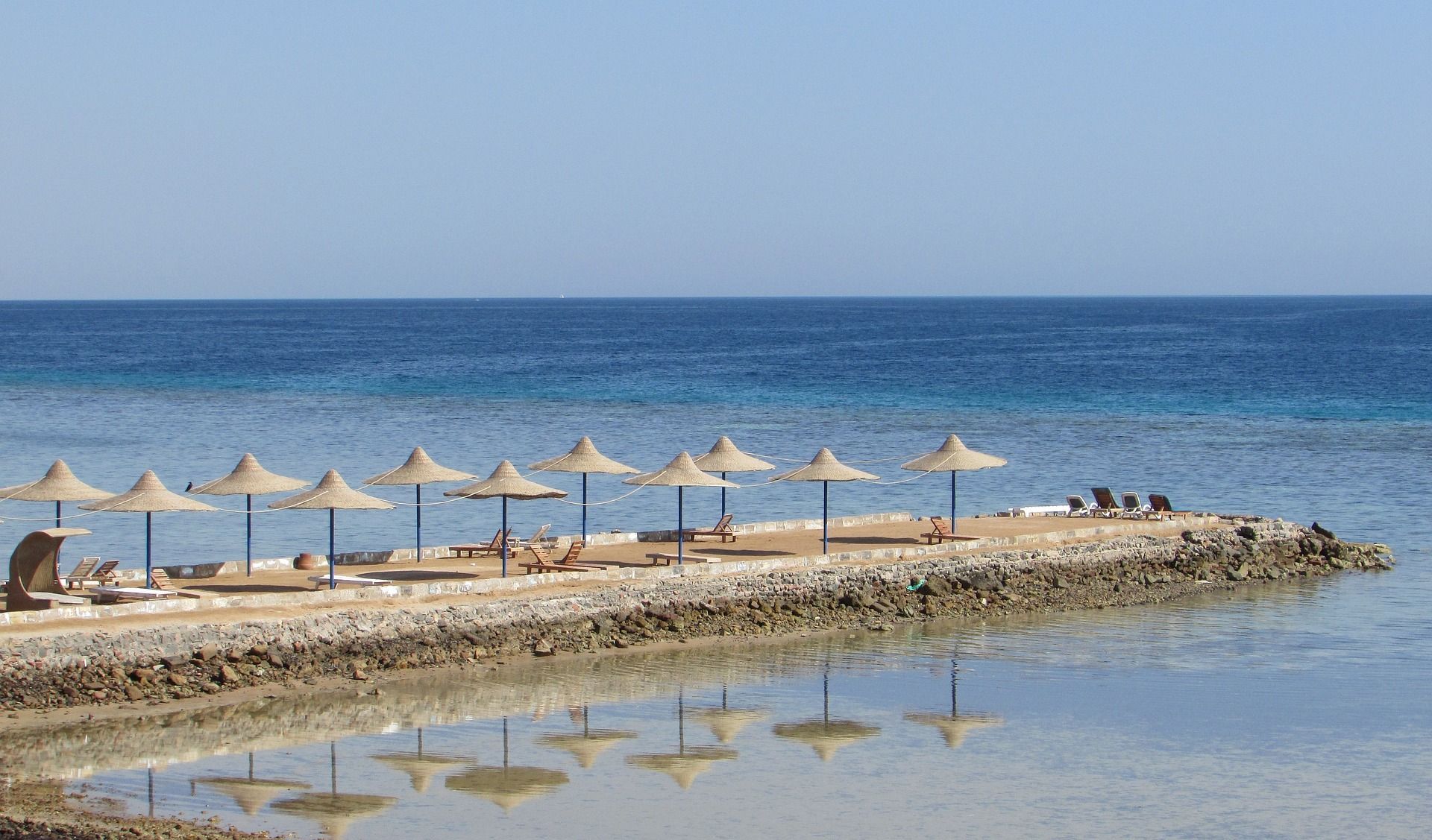 A row of umbrellas on a beach next to the ocean