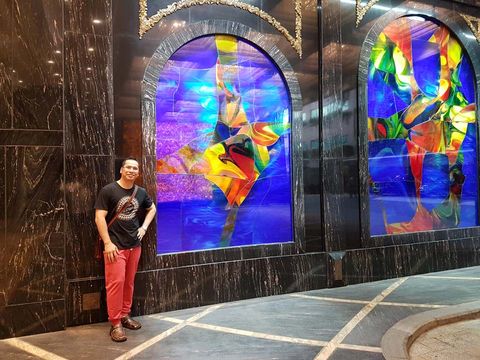 man posing next to a stained glass