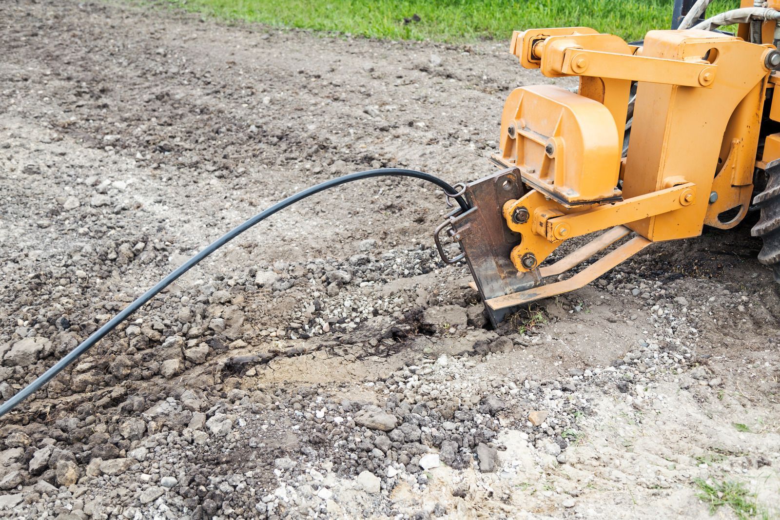 A yellow tractor is digging a hole in the ground.