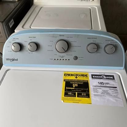 A white Whirlpool top-load washing machine with a blue control console and an EnergyGuide label on the lid.