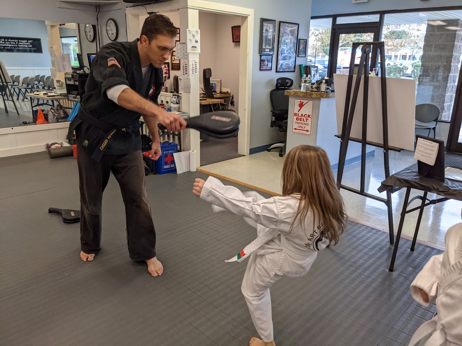 A young girl is practicing taekwondo in a gym.