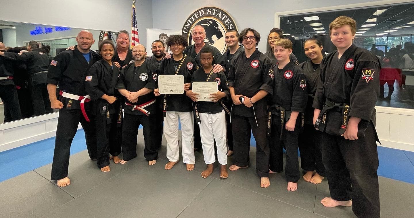 a group of people posing in front of a sign that says east west karate