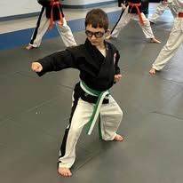 a man and a girl holding a certificate that says east west karate