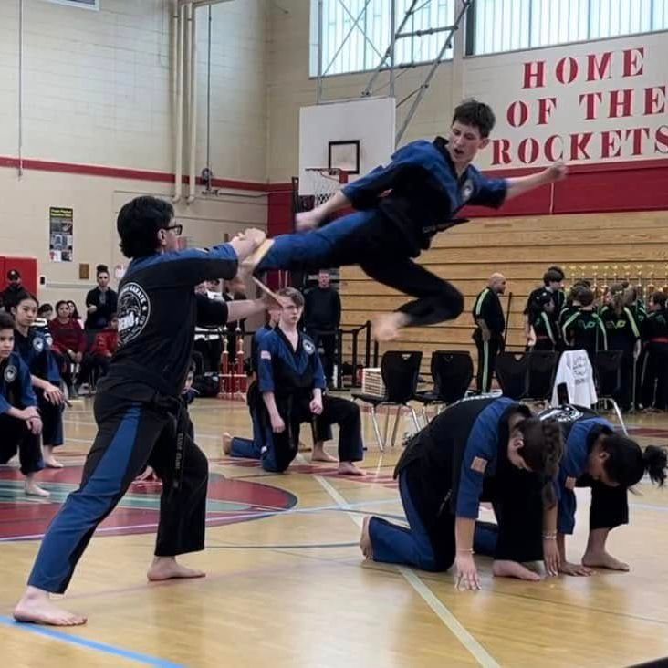 two young men are practicing karate in a gym