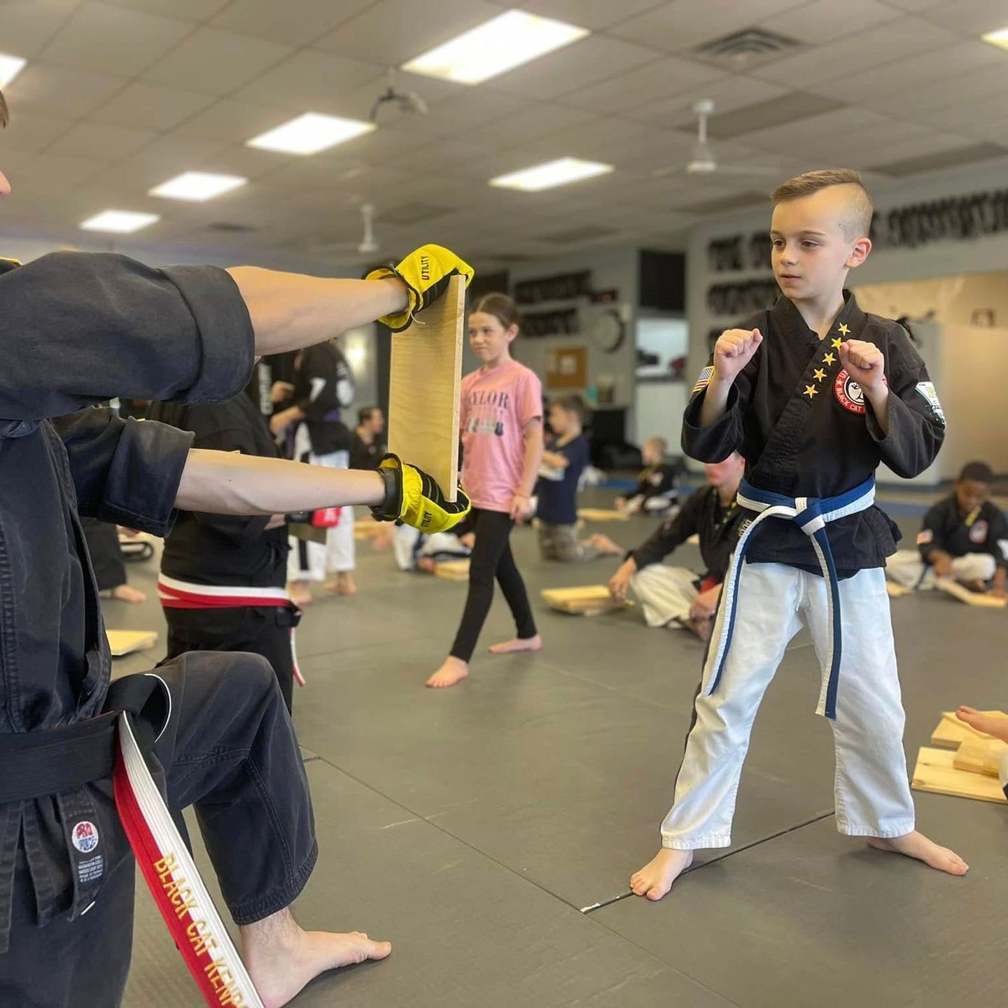 a boy and a girl are practicing taekwondo together .