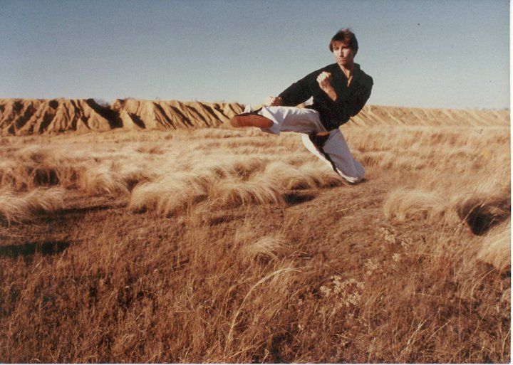 A man in a white karate uniform with a black belt