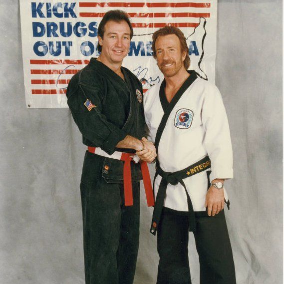A group of men are posing for a picture and one of them has a triangle on his shirt