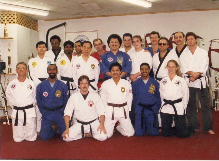 A group of men in karate uniforms are posing for a picture