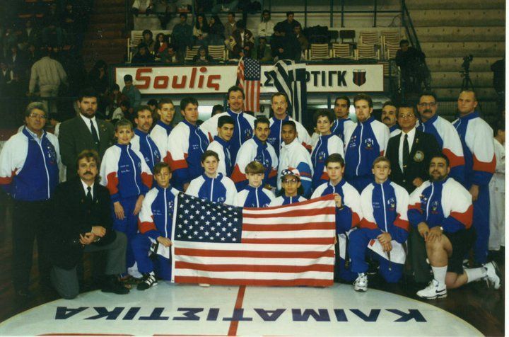 A group of people posing for a picture with one wearing a sweatshirt that says new york on it
