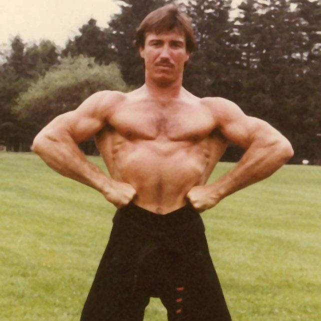 A group of people posing for a picture with one wearing a sweatshirt that says new york on it