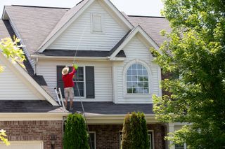 A man is standing on the roof of a house.