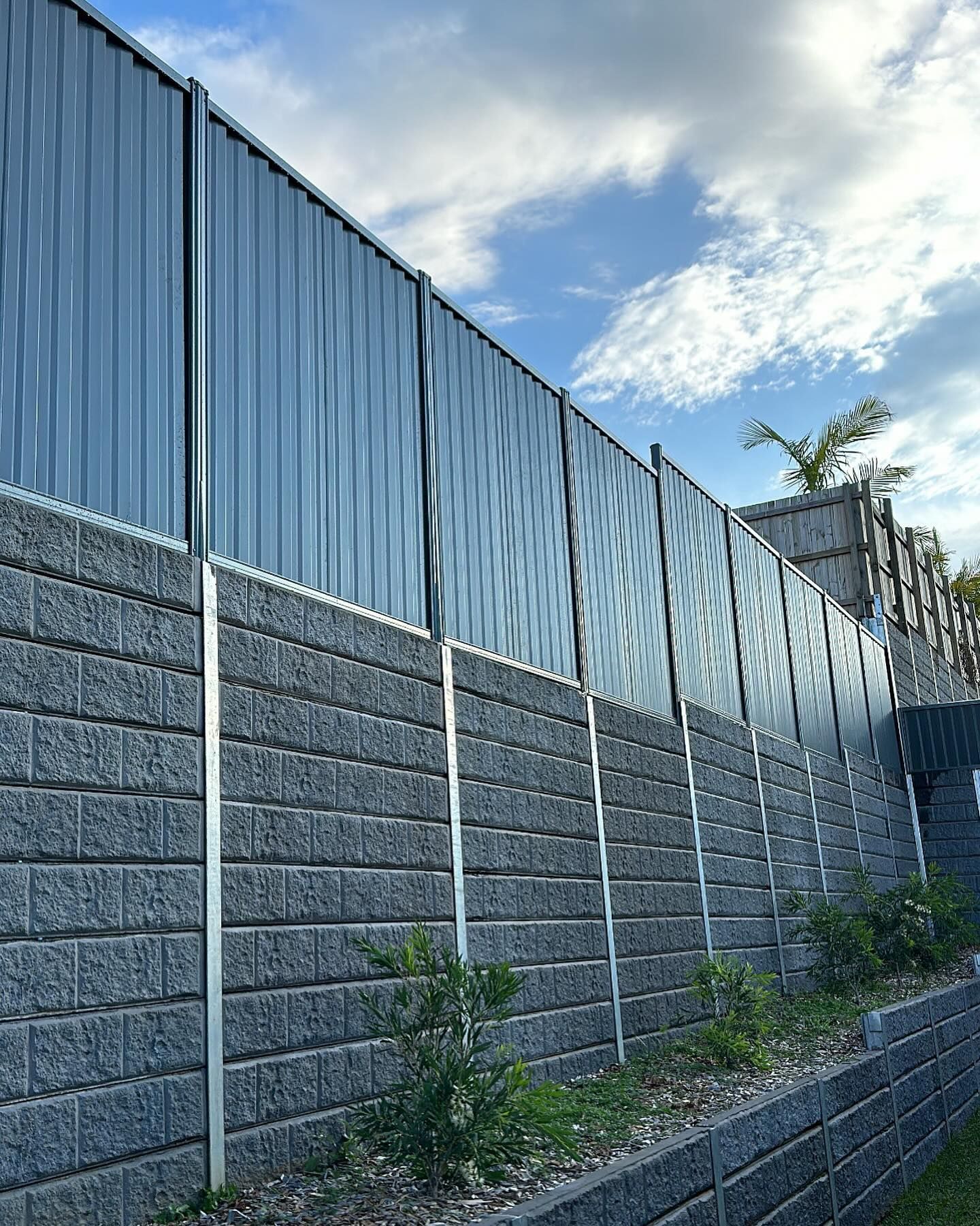 A Fence Made of Bricks and Metal With a Blue Sky in the Background — Fence & Deck Australia Pty Ltd in Lismore, NSW