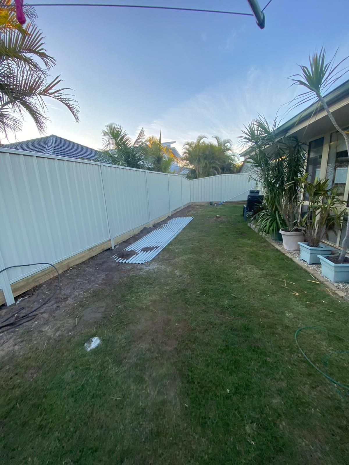 There is a White Fence in the Backyard of a House — Fence & Deck Australia Pty Ltd in Casino, NSW