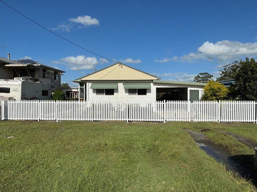 A House With a White Picket Fence in Front of It — Fence & Deck Australia Pty Ltd in Casino, NSW