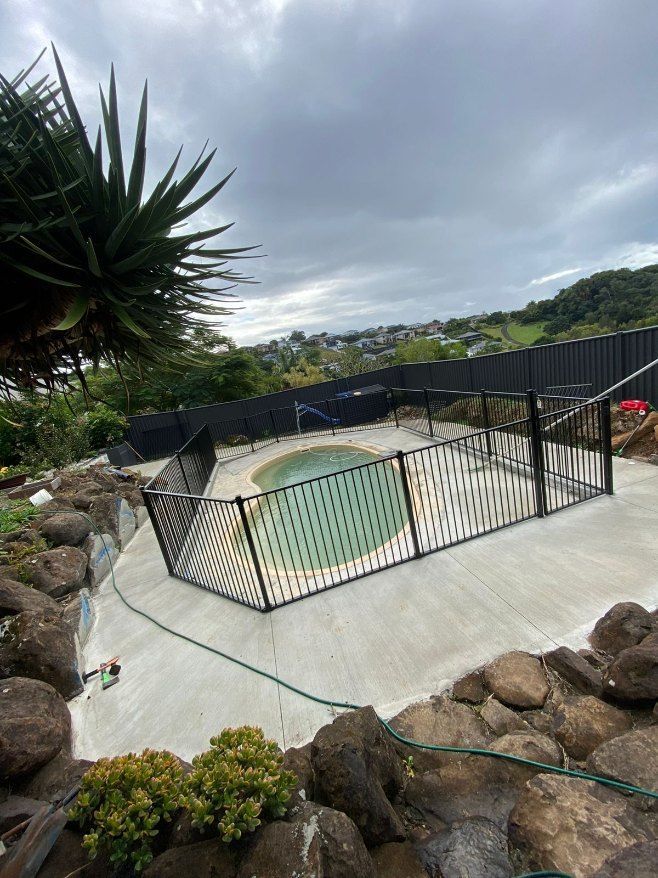 A Swimming Pool With a Fence Around It — Fence & Deck Australia Pty Ltd in Casino, NSW