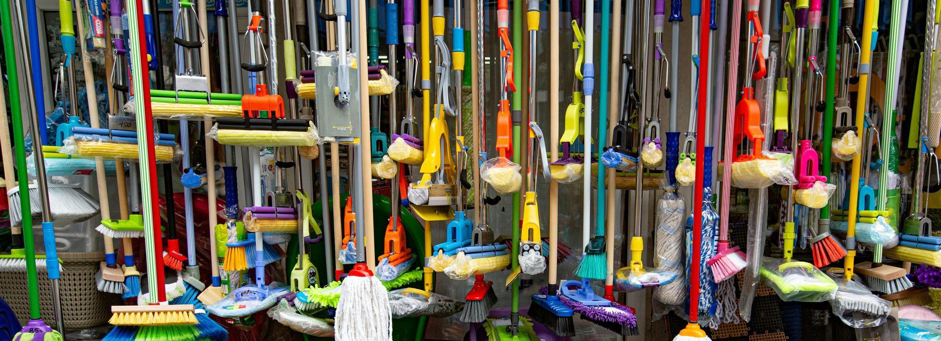Een aantal dweilkoppen en stelen hangen in een winkel
