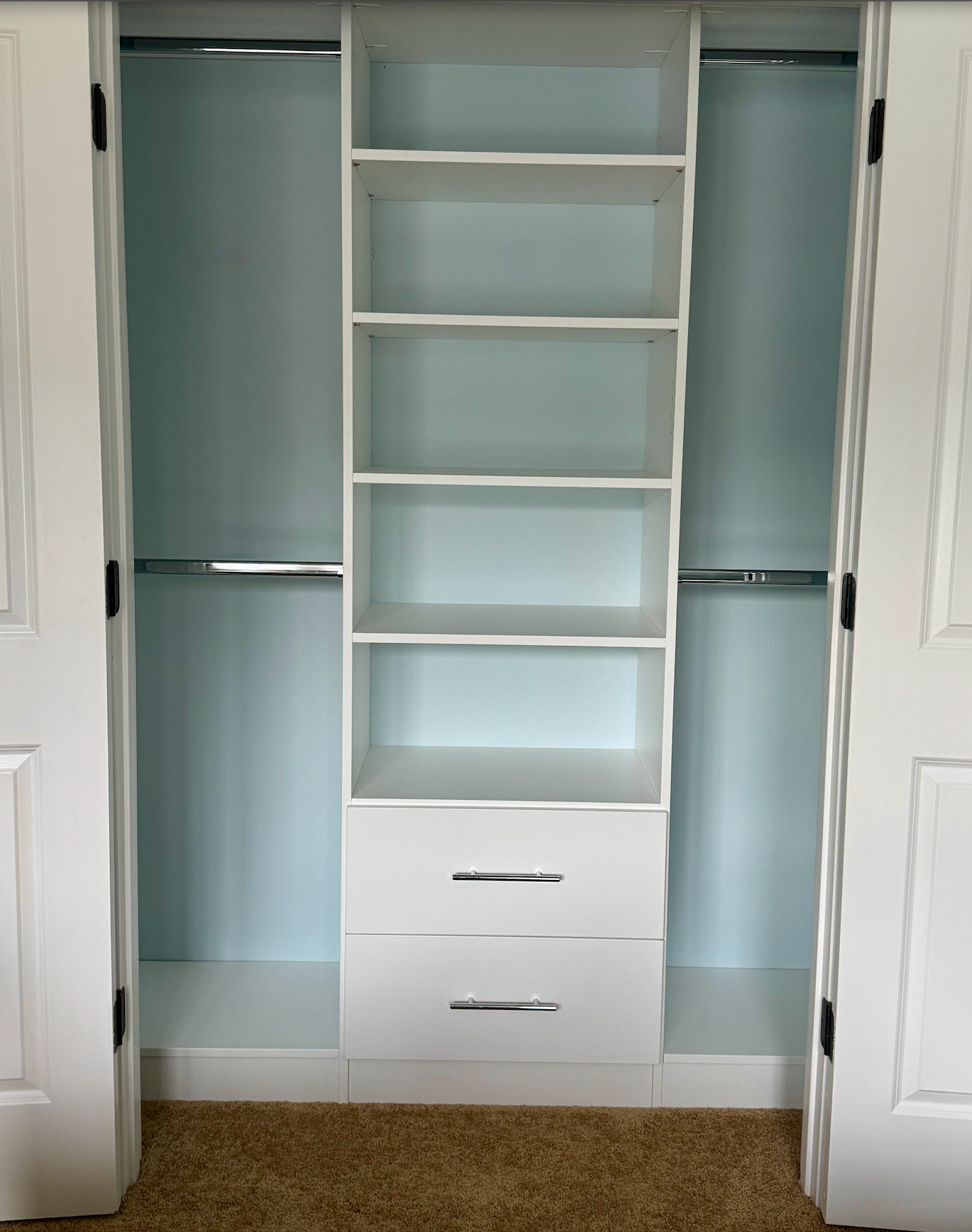 A walk in closet with lots of shelves and drawers